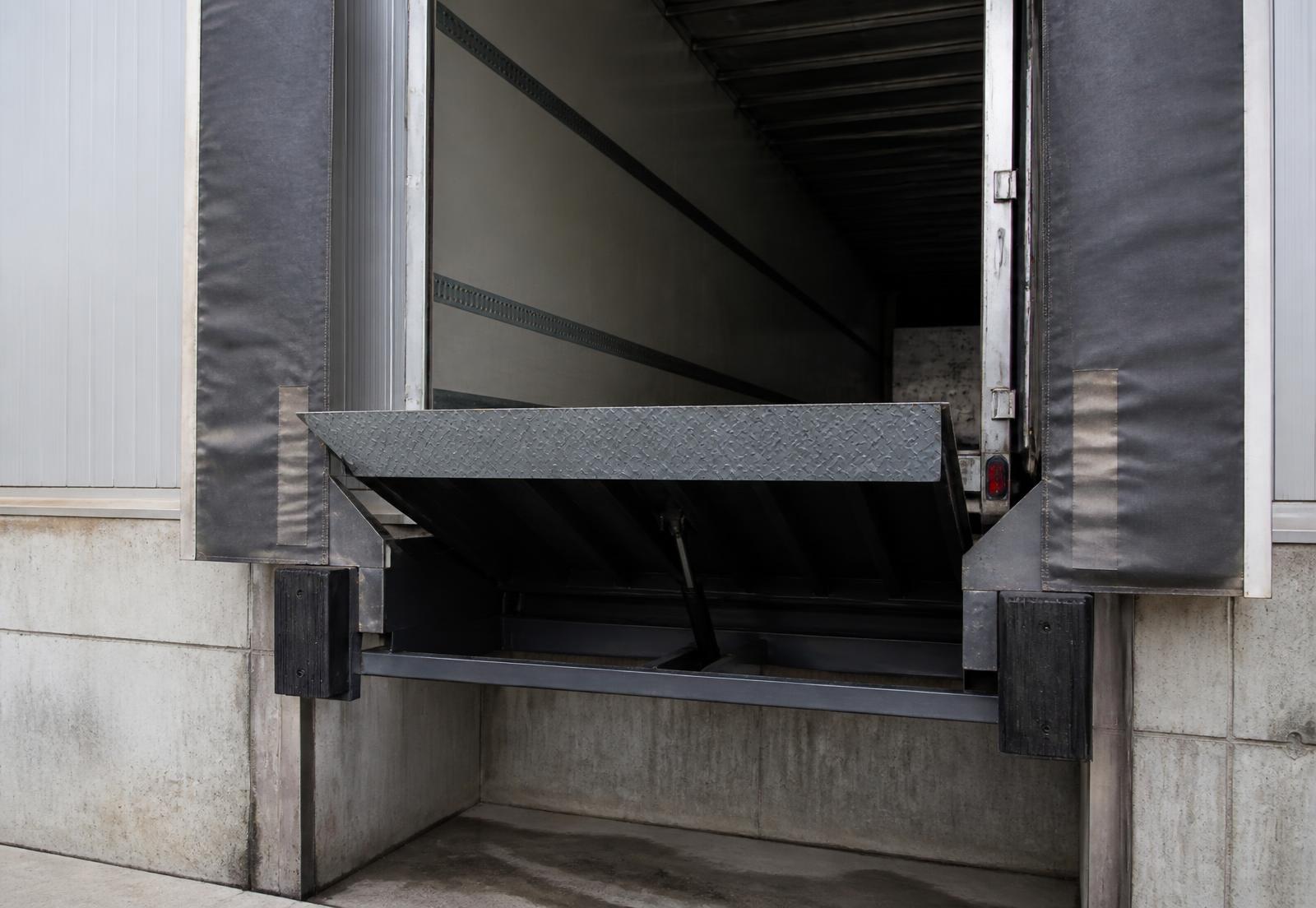 Loading dock with raised dock leveler and dock shelter